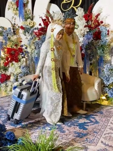 Suasana pengantin membawa koper saat di pelaminan bikin warganet salah fokus.